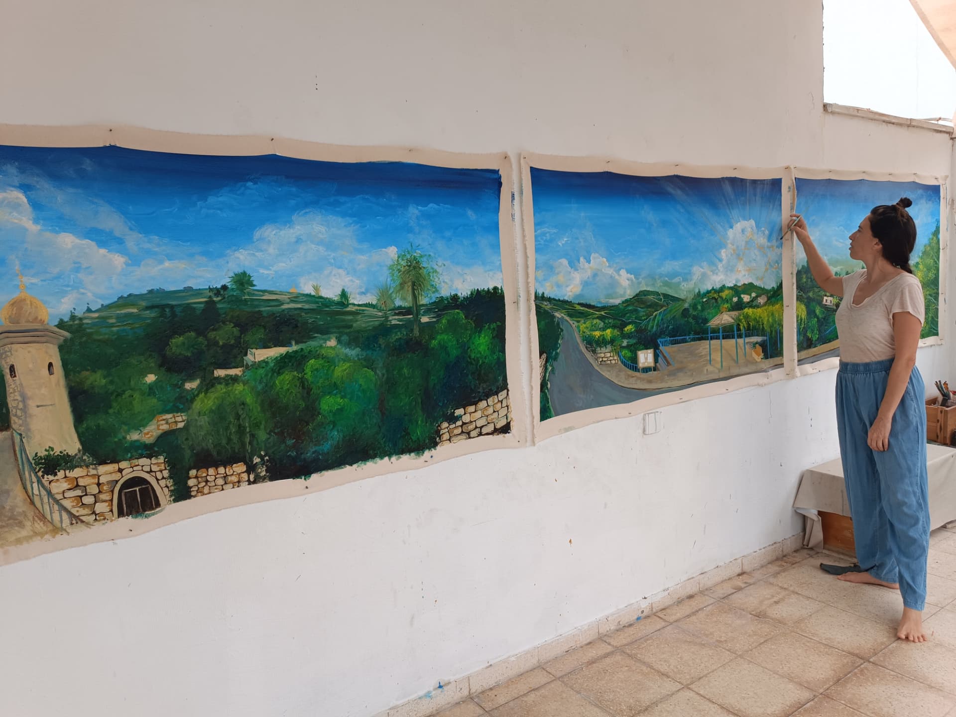 Working on a panoramic landscape painting on the studio rooftop